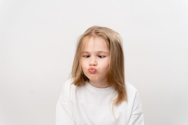 有趣的女孩在白色的背景上做鬼脸图片下载