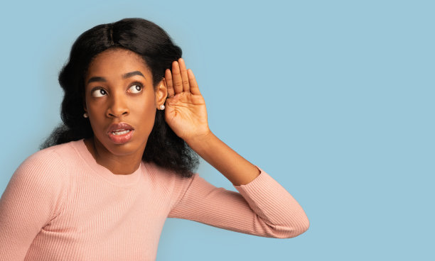 好奇的年轻黑人女性用手靠近耳朵试图偷听一些东西图片下载