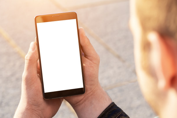 男人们在户外用手机手拉手发短信。图片下载