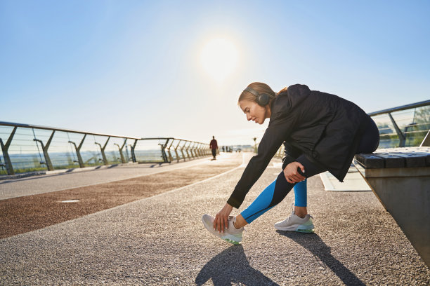 快乐的年轻女子戴着耳机在户外锻炼图片下载