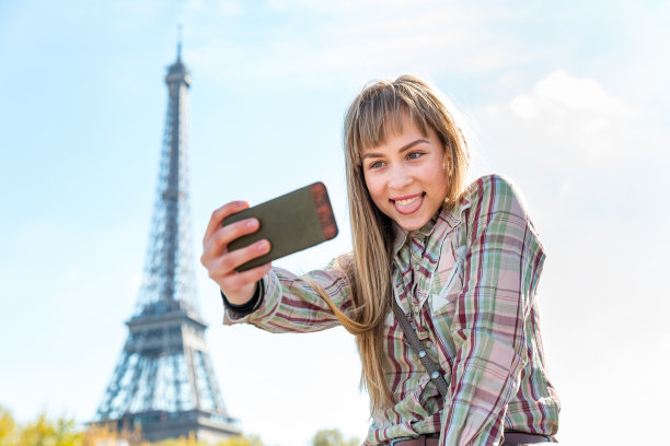 快乐的女孩在巴黎以埃菲尔铁塔为背景自拍图片下载