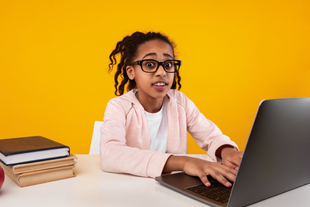 震惊的黑人女孩用笔记本电脑看着摄像头图片下载