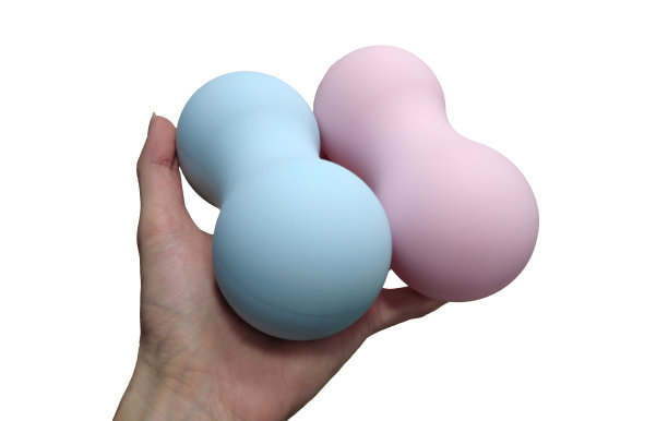 手握双按摩球放松肌肉孤立在一个白色的背景。按摩工具，球为触发点，肌筋膜按摩。图片下载