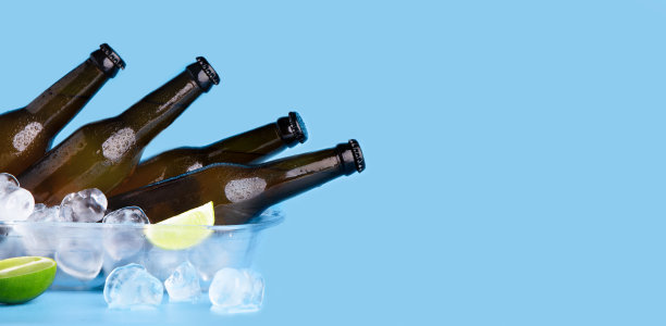 夏日聚会的提神饮料。满瓶的黑色啤酒，没有标签和流动的水滴图片下载