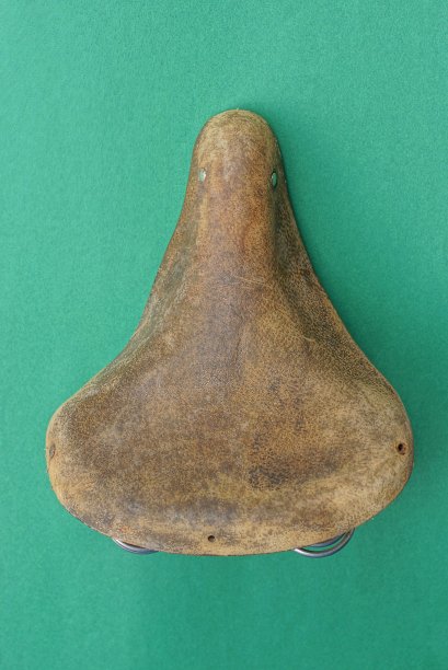 一个旧的棕色皮革把自行车的车座磨坏了图片下载