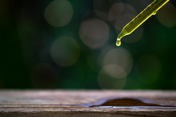 油滴从玻璃油滴在潮湿的木桌与灯光效果自然散焦背景。图片下载