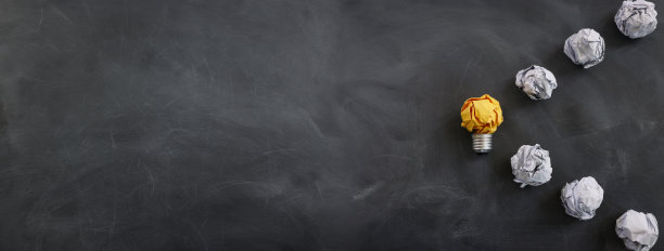 教育理念的形象。创意和创新。在黑板上，皱巴巴的纸就像灯泡一样图片下载