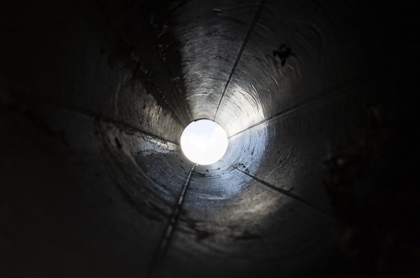 摘要黑色隧道用圆管制成。退出或无尽的概念。隧道尽头的一盏灯。图片下载