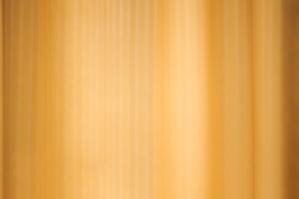 金色墙壁上透明窗帘的影子。模糊窗帘背景纹理设计图片下载