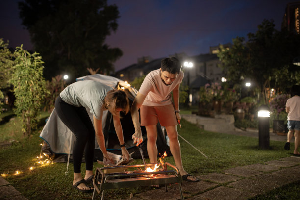 亚裔华人父母在自家后院搭起营火，进行周末度假活动图片下载