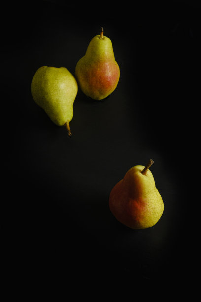 梨子放在黑色的木桌上图片下载