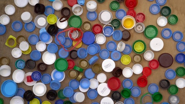 使用过的塑料饮料瓶盖和盖子。聚丙烯，聚乙烯。废物分类及回收图片下载