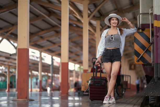快乐的亚洲女游客走在火车站里。图片下载
