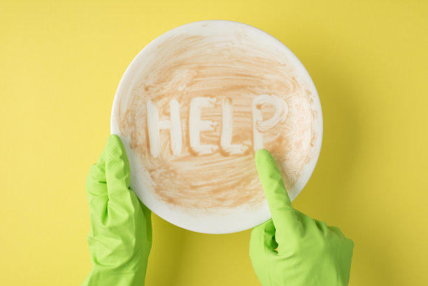 俯视图照片的手在绿色橡胶手套指示与食指在脏盘子上的铭文帮助孤立的黄色背景图片下载