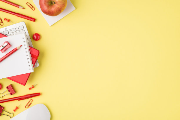 上面的照片，笔记本，卷笔刀，钢笔，键盘，毡尖，回形针，电脑鼠标和苹果孤立在黄色的背景与空白图片下载