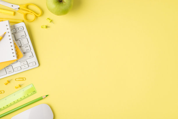 头顶上的照片记事本，尺，铅笔，钢笔，键盘，毡头，回形针，电脑，鼠标和苹果孤立在黄色的背景与空白图片下载