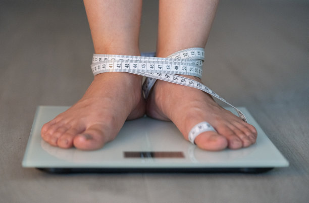 浴室秤上的女性脚与卷尺库存照片图片下载