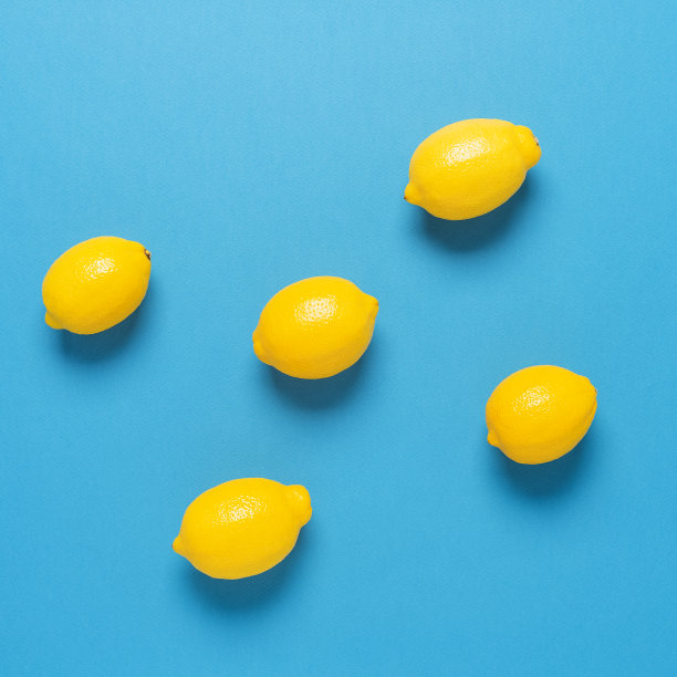 蓝纸背景下的成熟柠檬。俯视图，平放。广场的照片。图片下载