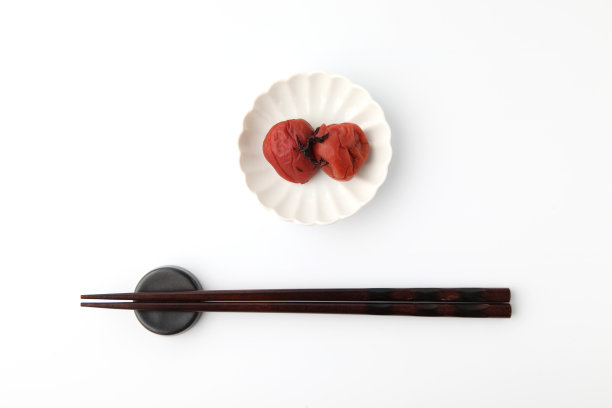 日本泡菜盐梅子与筷子孤立在白色背景图片下载