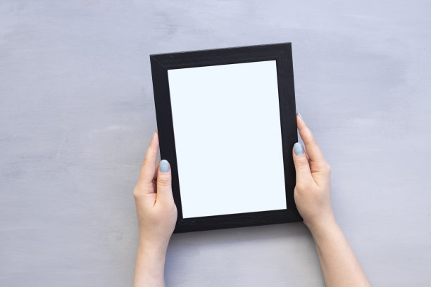 女人的手拿着空白的相框在白色的背景。近距离图片下载