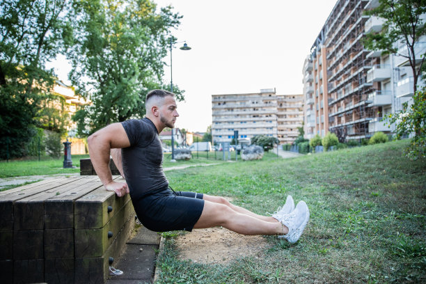 一个年轻的白人男孩在公园外面做各种肌肉训练和伸展运动图片下载
