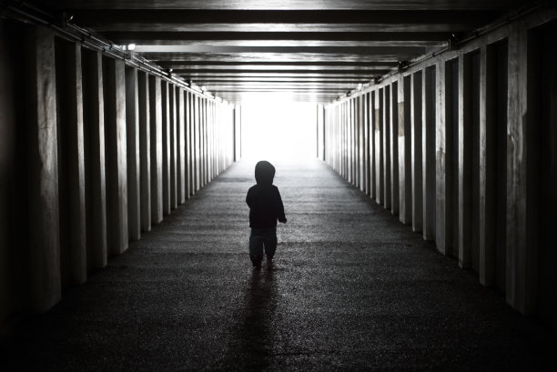 那孩子从黑暗走向光明。危险的人走过黑暗的隧道图片下载