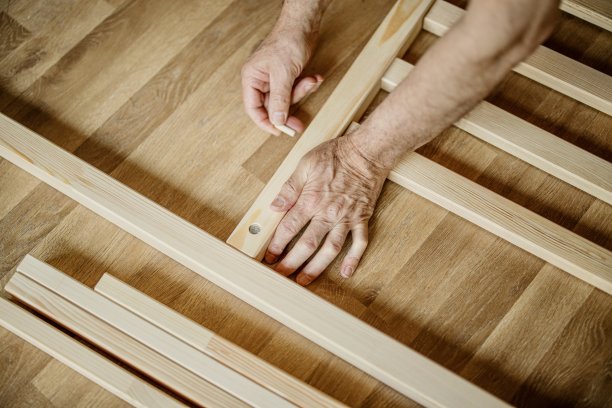 一个男人组装床架的双手的特写图片下载