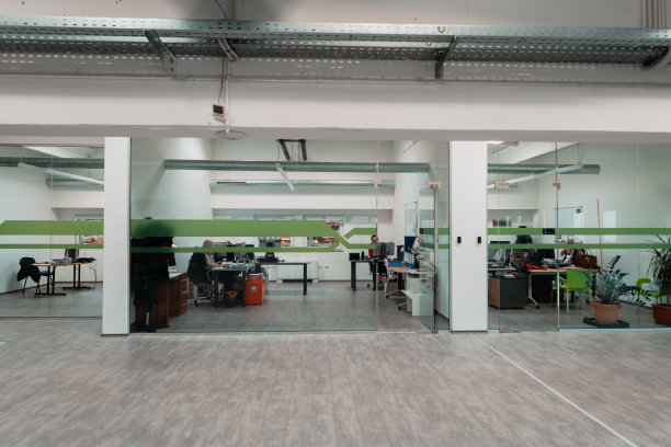 一个现代化的玻璃办公室在行业。用电脑、平板电脑和现代设备办公。图片下载