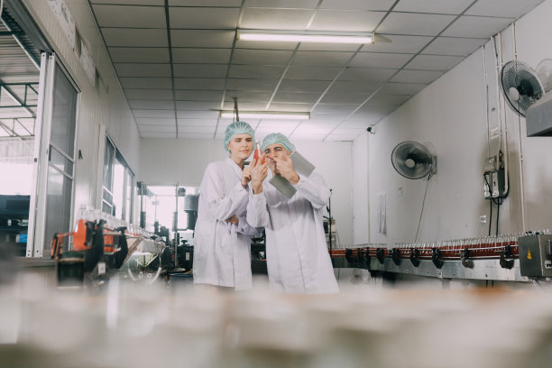 工人在工厂检查产品。工人在检查饮料生产厂的生产线。工作的概念图片下载