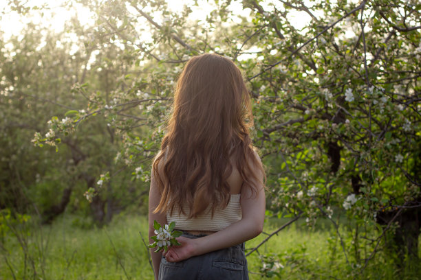 快乐的女孩在公园的花丛中享受阳光灿烂的一天图片下载