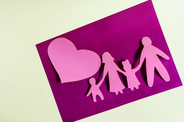 明亮的红色人物和一个大的红色的心在彩色的背景。家庭关系的概念。纸板人物的成人和儿童近距离概念的一个幸福的家庭图片下载