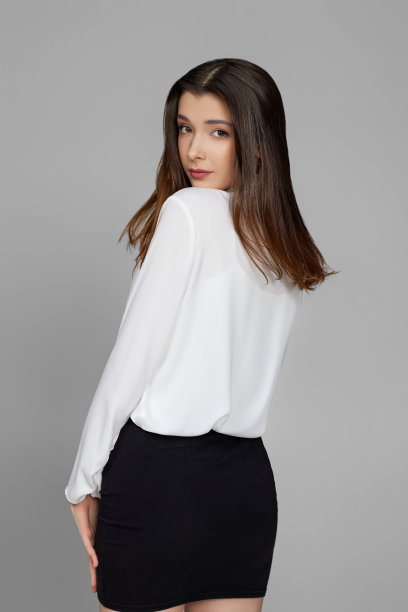 穿着白衬衫和白裙子的女商人向后看图片下载