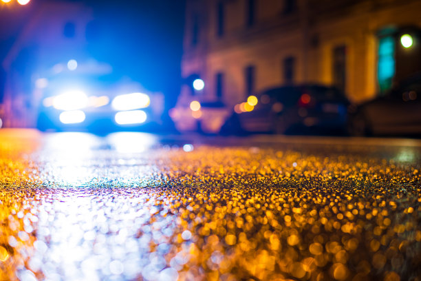 秋雨夜城。骑乘汽车的前灯。市中心的住宅建筑。五彩缤纷的颜色。图片下载