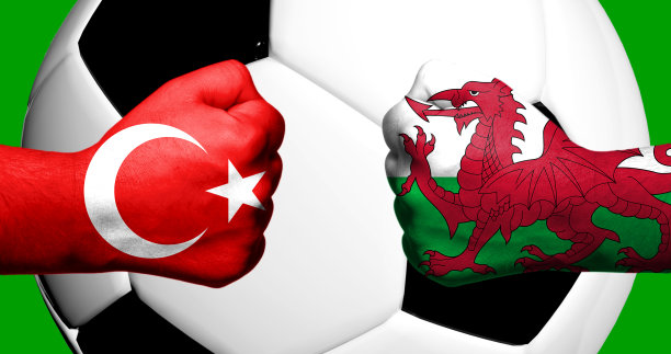 土耳其和威尔士国旗绘在紧握的拳头上，以足球为背景的3D混合媒体概念图片下载