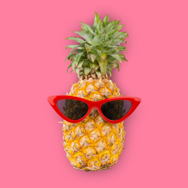 新鲜的菠萝戴着红色的太阳镜，粉红色的背景。图片下载