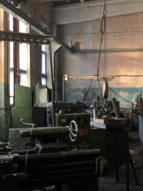 晨光透过老工厂的大窗户照进来，老工厂配备了大型机器，用于铣削和加工金属零件。图片下载
