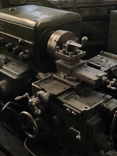 一个旧的金属加工机器的一部分的特写照片。手动金属加工机仍处于工作状态，可以进行与金属加工、铣削、车削、钻孔有关的复杂操作。图片下载