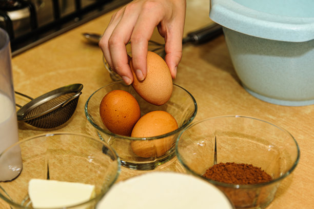 一个女人在为一个美味的可可蛋糕混合原料的特写照片。图片下载