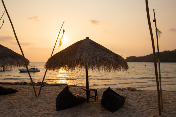 暑假的概念。美丽的剪影空太阳床日落或日出在普吉岛的海滩，泰国。图片下载