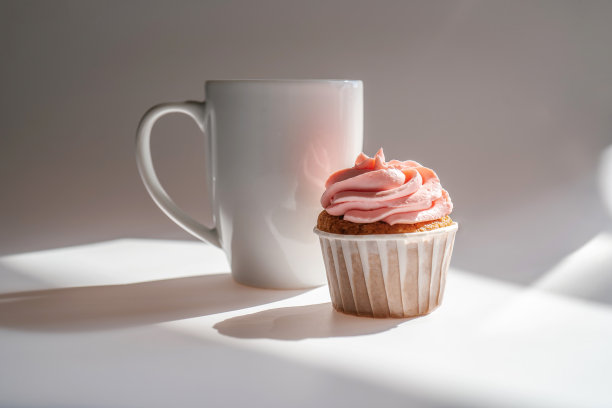 纸杯蛋糕或松饼就在一杯咖啡旁边。图片下载