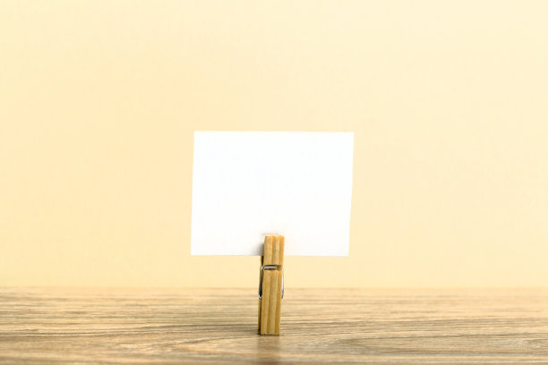 木背景上印有白色便利贴的晾衣夹。图片下载