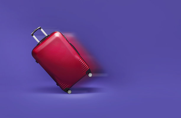 红色行李箱在紫色背景上快速滚动图片下载