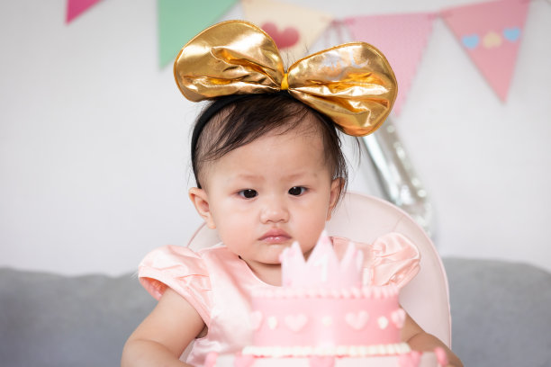 可爱的亚洲小女孩用粉红色公主蛋糕庆祝她的第一个生日。图片下载