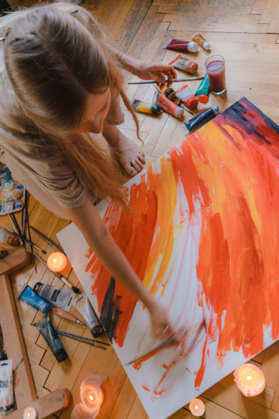 一个女人在她公寓的地板上画画图片下载