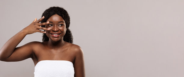 皮肤护理步骤。美丽开朗的非洲裔美国女性，手指靠近脸图片下载