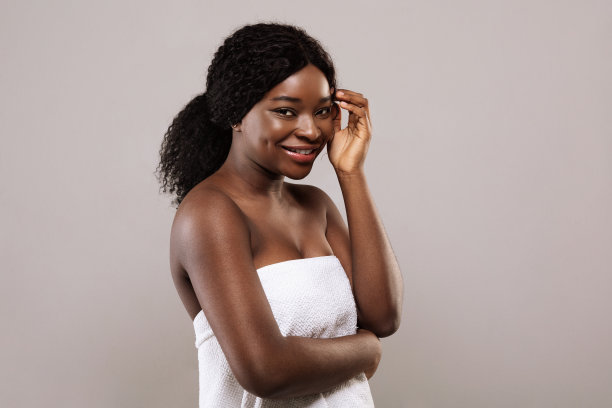 自然美景。年轻微笑的黑人女性穿着浴巾的肖像图片下载