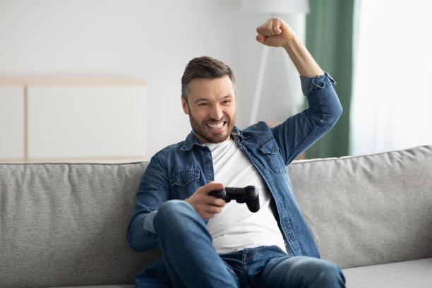 情绪激动的中年人在家玩电子游戏图片下载