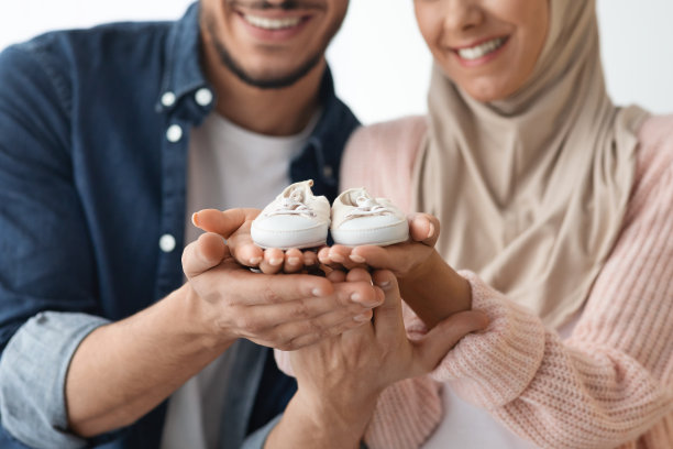 的父母。快乐的穆斯林夫妇拿着小婴儿鞋在手中图片下载