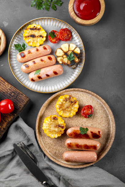 烤香肠配蔬菜和酱汁。夏日烧烤，香肠，玉米和西红柿。俯视图，垂直照片图片下载