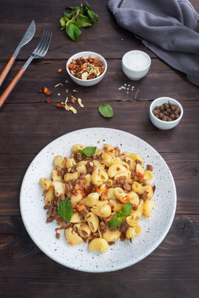 用碎牛肉和蔬菜炖意大利面，海军蓝风格的通心粉。深色木制背景。副本的空间。图片下载